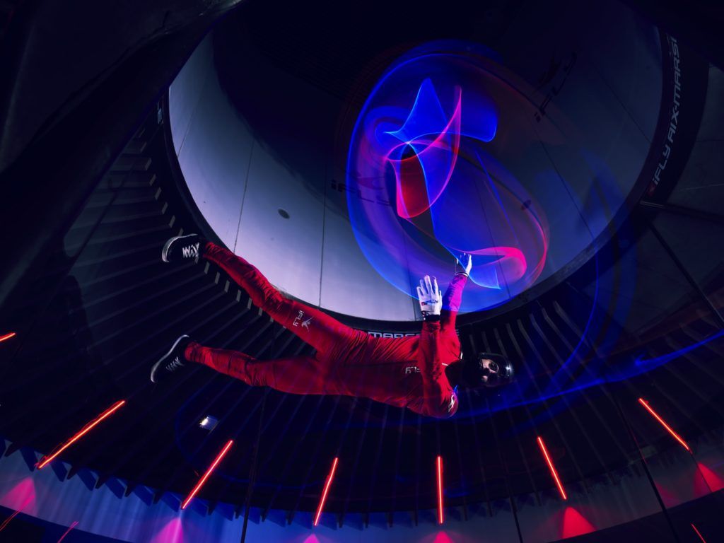 Athlète de chute libre indoor photographié par Antonin Grenier avec une combinaison lumineuse